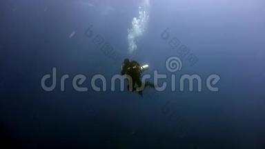 深海潜水者在红海深处游泳的剪影。